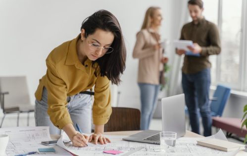 businesswoman-working-while-her-teammates-are-talking businesswoman-working-while-her-teammates-are-talking