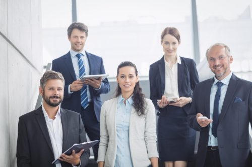 Portrait of confident businesspeople standing on staircase in office